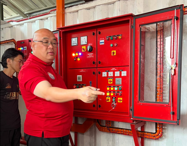 Team firma kontraktor berbincang tentang latihan sistem keselamatan kebakaran.