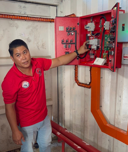 Juruteknik memeriksa panel sistem kebakaran bangunan.
